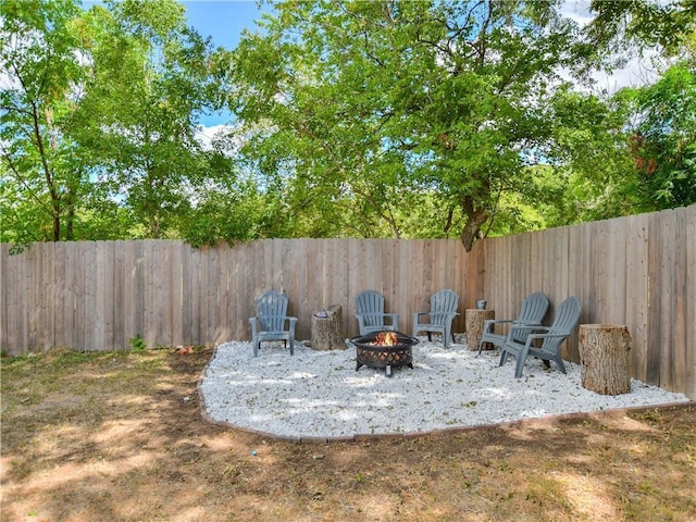 view of yard featuring a fenced backyard, a fire pit, and a patio area