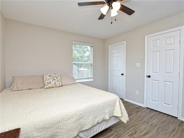 bedroom featuring baseboards, a ceiling fan, and wood finished floors