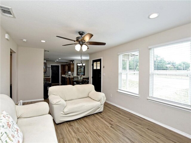 living room with ceiling fan, recessed lighting, baseboards, wood finished floors, and visible vents
