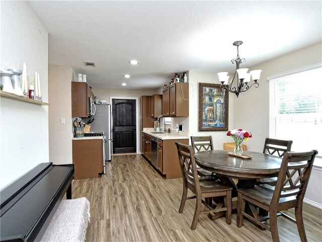 dining area featuring recessed lighting, light wood-style flooring, a notable chandelier, and visible vents