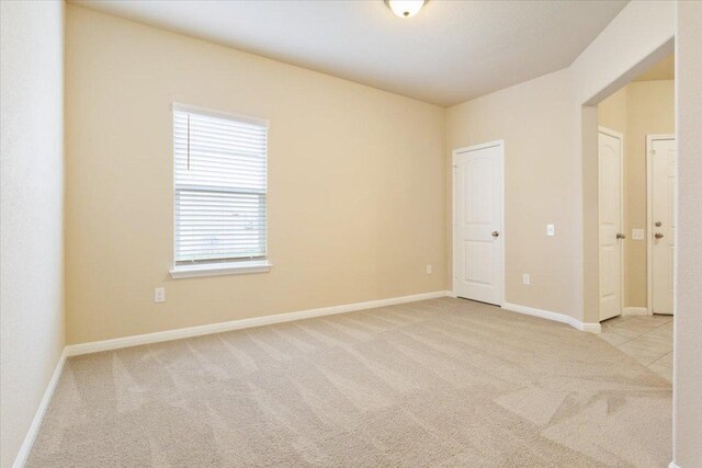 unfurnished room with carpet flooring and baseboards