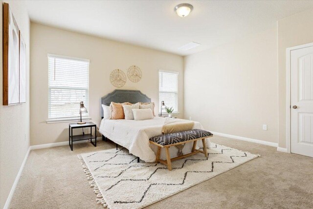 carpeted bedroom featuring baseboards and multiple windows