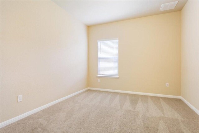 carpeted spare room featuring baseboards