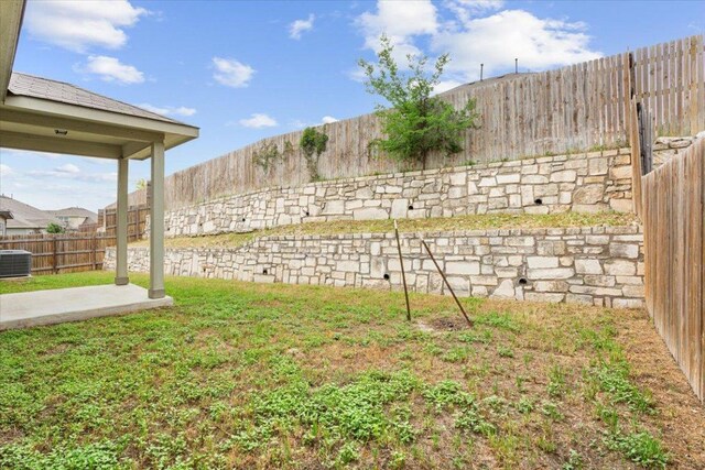 view of yard with a patio, a fenced backyard, and central air condition unit