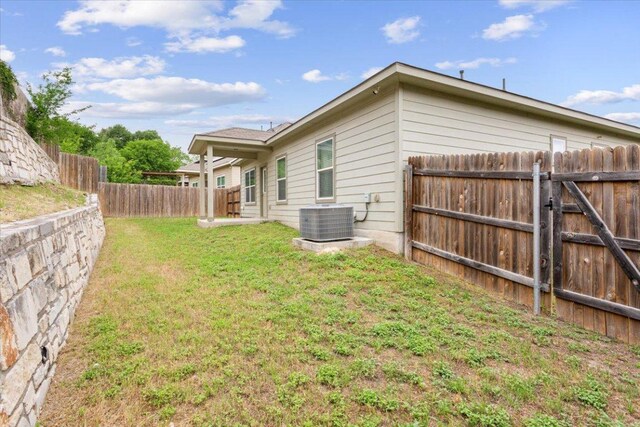 view of yard with central AC unit and a fenced backyard