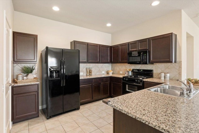 1504 Maier Dr, Pflugerville, TX 78660 - kitchen with black appliances, a sink, dark brown cabinets, tasteful backsplash, and light stone countertops