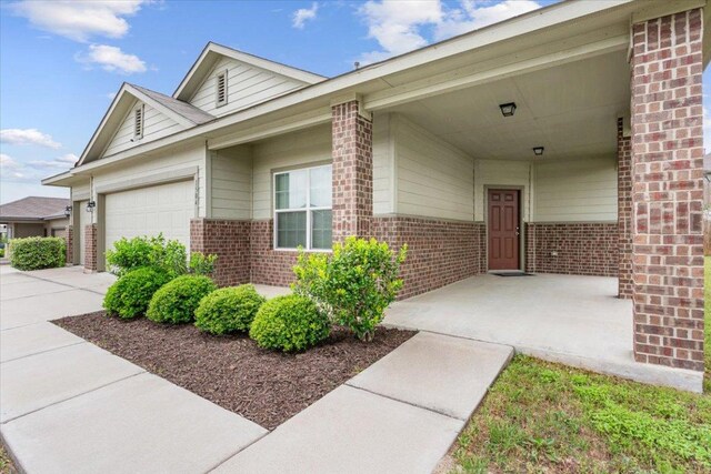 exterior space with concrete driveway, brick siding, and a garage