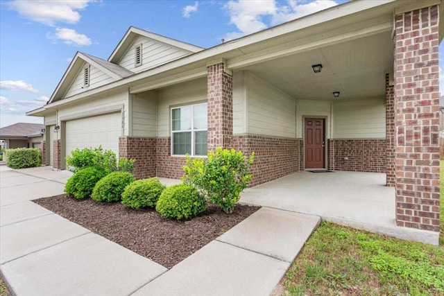 1504 Maier Dr, Pflugerville, TX 78660 - doorway to property featuring brick siding, a garage, and concrete driveway