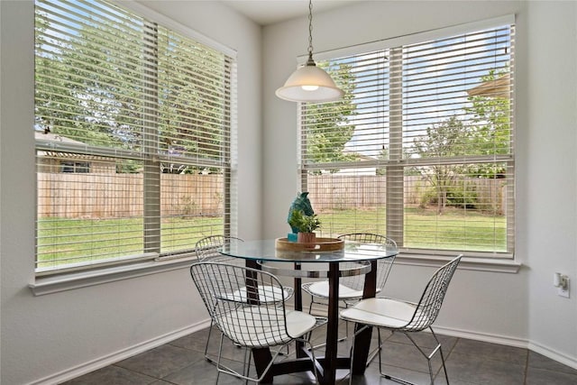 dining area featuring baseboards, tile patterned flooring, and a wealth of natural light