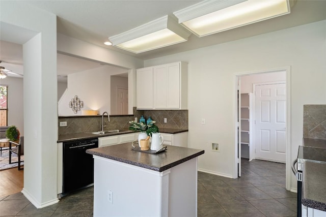 kitchen with a sink, dark countertops, black dishwasher, and white cabinetry
