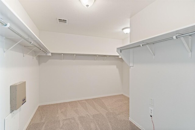 walk in closet featuring light colored carpet and visible vents