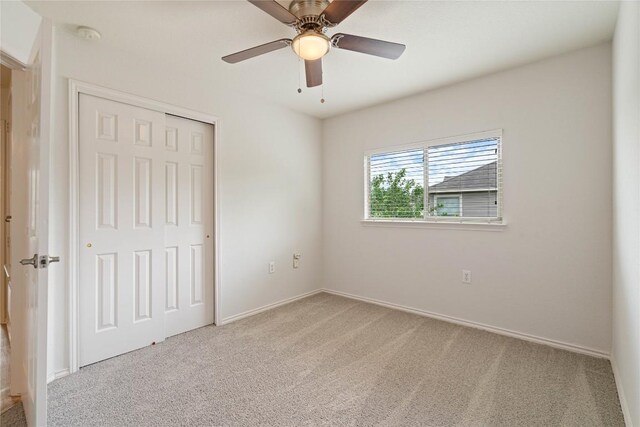 unfurnished bedroom with a closet, carpet, ceiling fan, and baseboards