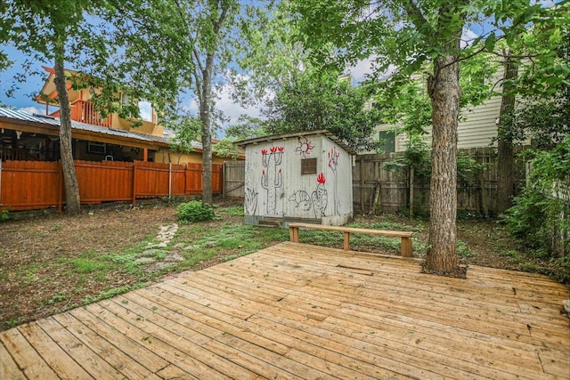 wooden deck with an outbuilding, a shed, and a fenced backyard