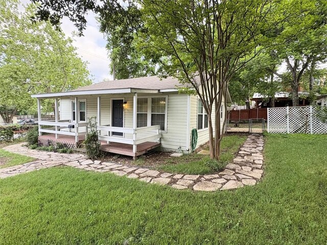 view of front of property featuring fence, a porch, and a front yard