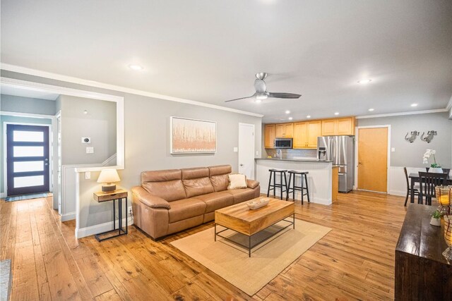living area with crown molding, a ceiling fan, light wood finished floors, and recessed lighting