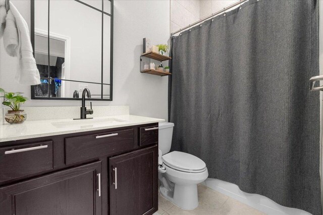 bathroom with vanity, tile patterned flooring, toilet, and curtained shower