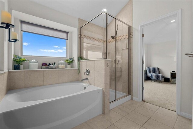 ensuite bathroom with tile patterned floors, a shower stall, ensuite bath, and a bath