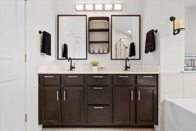 bathroom featuring double vanity, a sink, a shower with door, and a bath