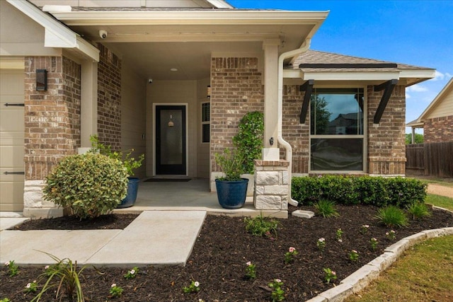 entrance to property with brick siding and fence