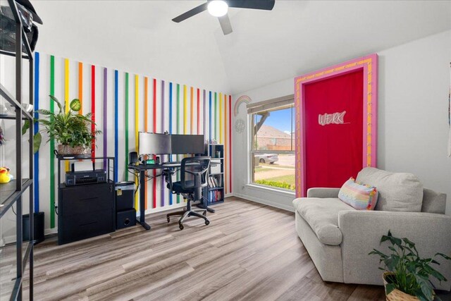 office with a ceiling fan, vaulted ceiling, wood finished floors, baseboards, and wallpapered walls