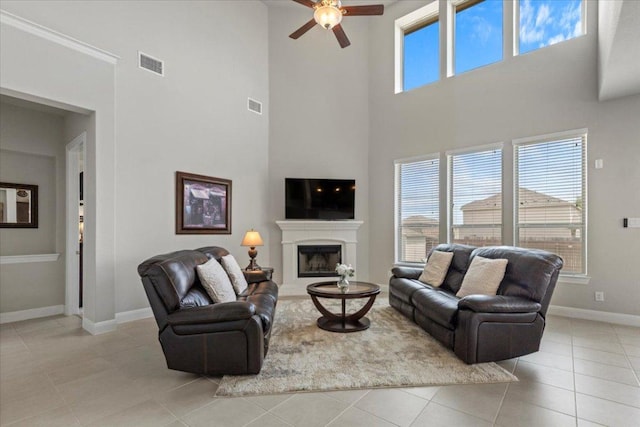 1800 Erie Dr, Leander, TX 78641 - tiled living area with a towering ceiling, a ceiling fan, and a fireplace with raised hearth