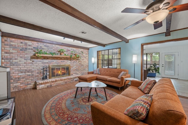 3909 Alderwood Ln, Temple, TX 76502 - living area with wood finished floors, a textured ceiling, beamed ceiling, a fireplace, and ceiling fan