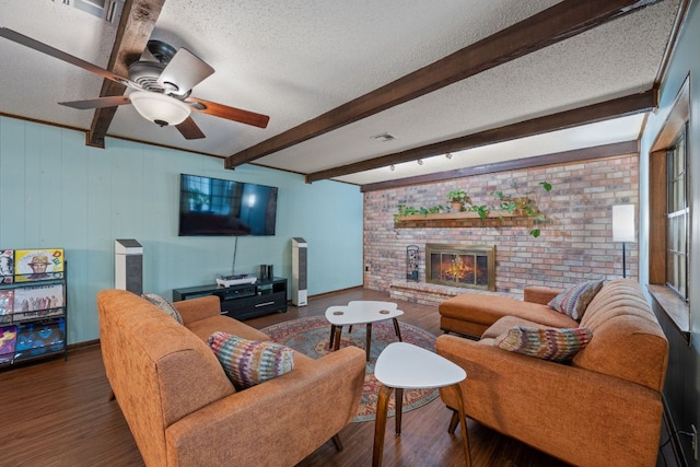 3909 Alderwood Ln, Temple, TX 76502 - living room with a textured ceiling, wood finished floors, a ceiling fan, a fireplace, and beam ceiling