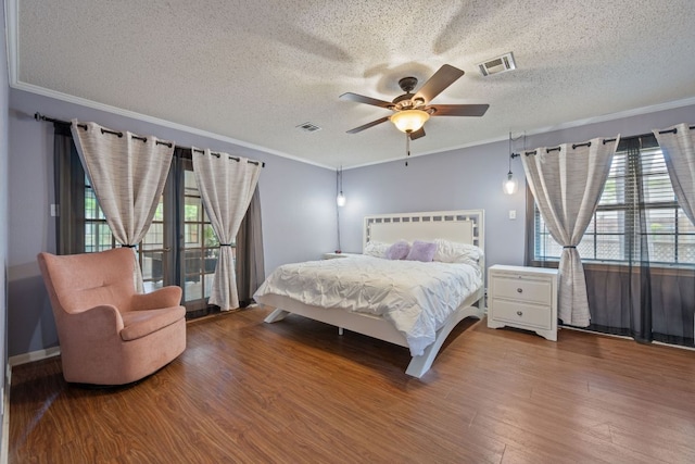 3909 Alderwood Ln, Temple, TX 76502 - bedroom featuring multiple windows, a textured ceiling, wood finished floors, crown molding, and ceiling fan