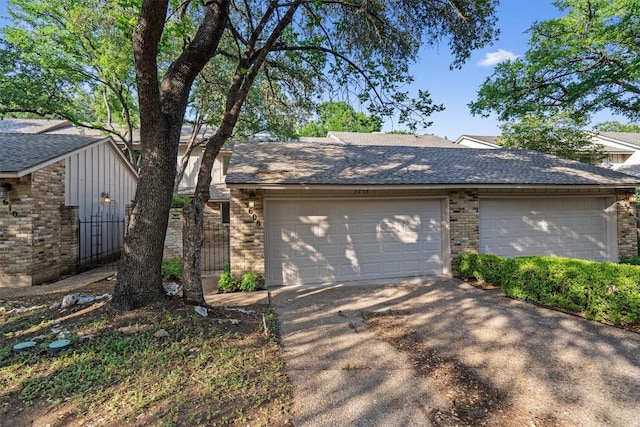 3608 Branigan Ln, Austin, TX 78759 - view of front of home with concrete driveway, brick siding, an attached garage, and roof with shingles