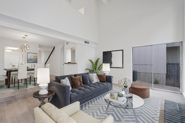 3608 Branigan Ln, Austin, TX 78759 - living area with wood finished floors, a towering ceiling, baseboards, and a chandelier