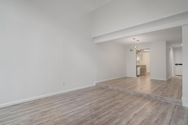 3608 Branigan Ln, Austin, TX 78759 - unfurnished living room with light wood finished floors, baseboards, and a chandelier