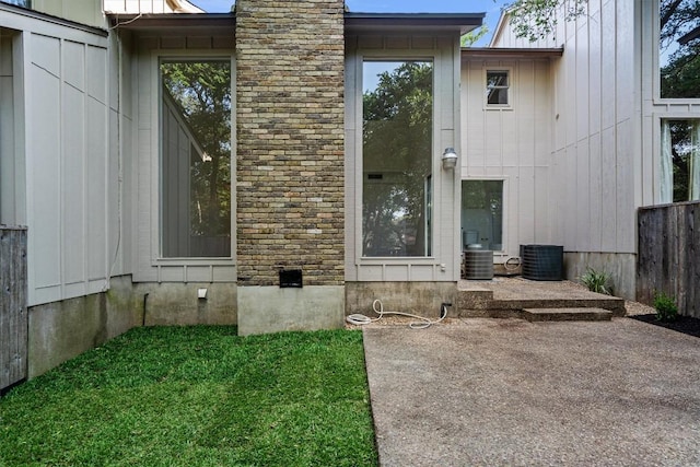 3608 Branigan Ln, Austin, TX 78759 - doorway to property featuring board and batten siding, central AC unit, and a patio