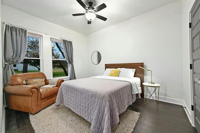 bedroom featuring baseboards, a ceiling fan, and dark wood finished floors