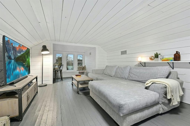living room with wood walls, lofted ceiling, hardwood / wood-style floors, and wooden ceiling
