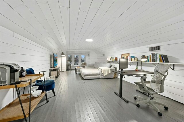 home office with wooden walls, wood-type flooring, lofted ceiling, visible vents, and wood ceiling