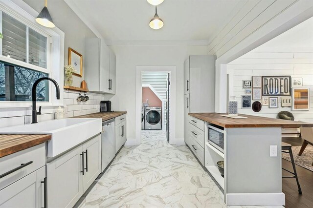 kitchen with separate washer and dryer, appliances with stainless steel finishes, and butcher block counters