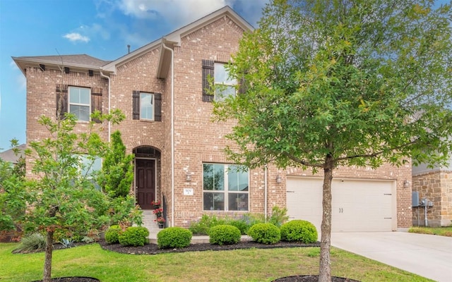 traditional-style home featuring concrete driveway, a front lawn, and brick siding
