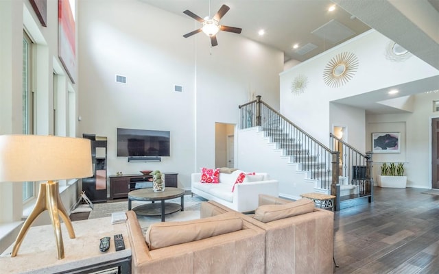 living room with visible vents, wood finished floors, a high ceiling, stairway, and a ceiling fan