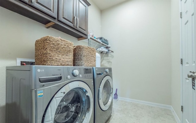washroom featuring cabinet space, baseboards, and washer and dryer