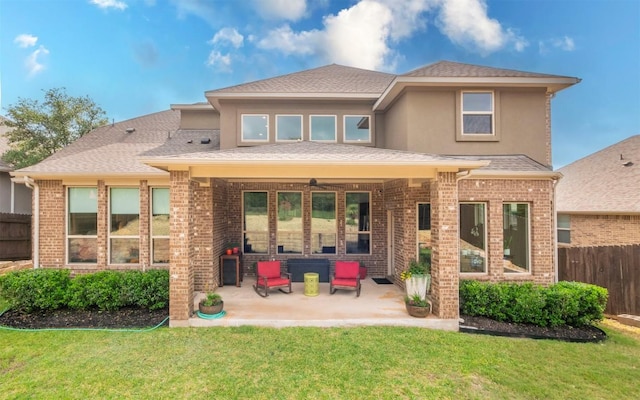 rear view of house with a patio area, fence, and a yard