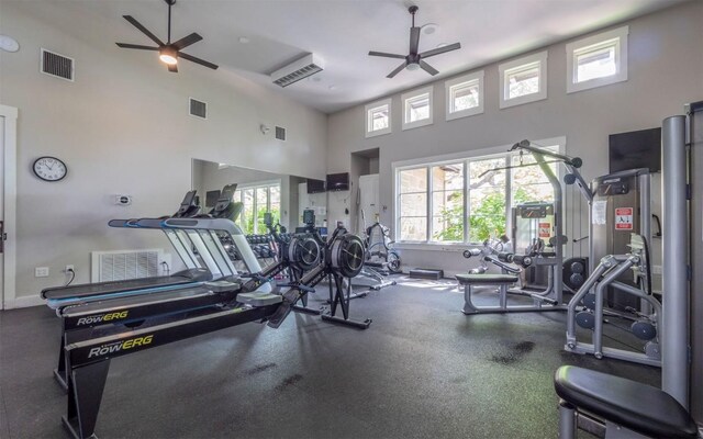 workout area with a high ceiling, a ceiling fan, and visible vents