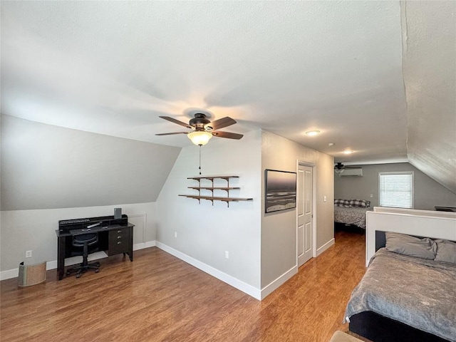 209 Lake Frst, Canyon Lake, TX 78133 - bedroom featuring baseboards, an AC wall unit, light wood finished floors, and lofted ceiling