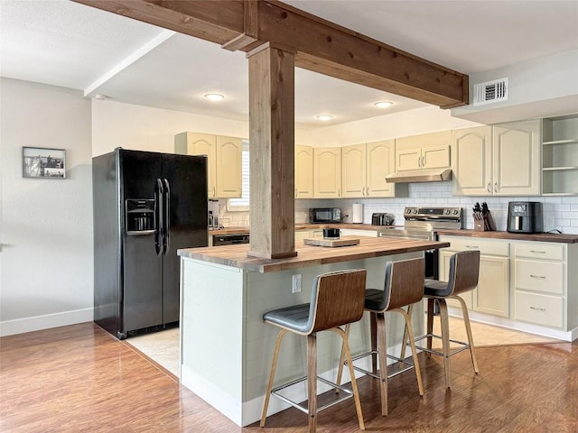 209 Lake Frst, Canyon Lake, TX 78133 - kitchen with backsplash, black appliances, butcher block countertops, and under cabinet range hood