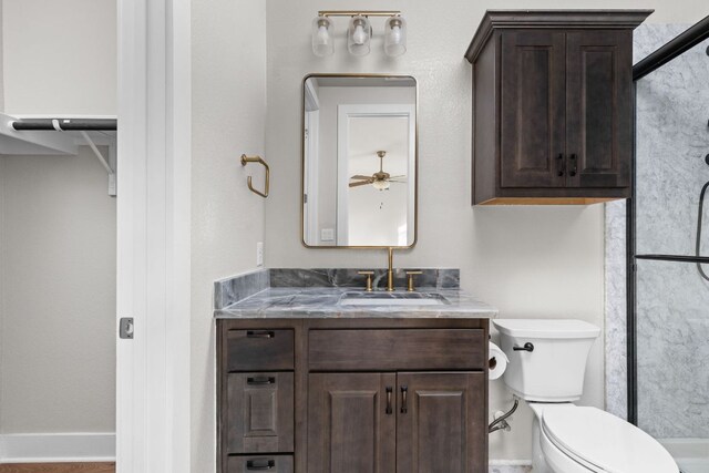 full bath with vanity, toilet, a ceiling fan, baseboards, and an enclosed shower