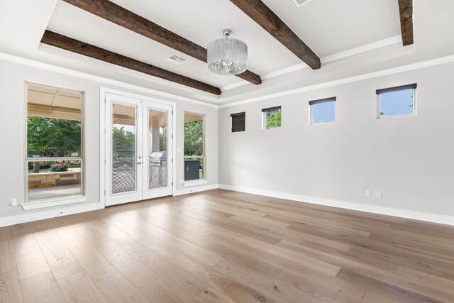 unfurnished room featuring beam ceiling, baseboards, wood finished floors, visible vents, and ornamental molding