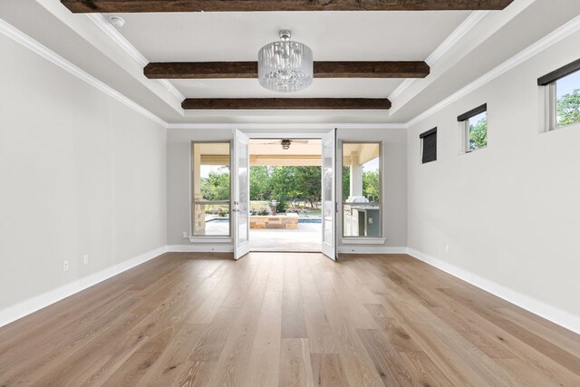 empty room with crown molding, baseboards, beam ceiling, and wood finished floors
