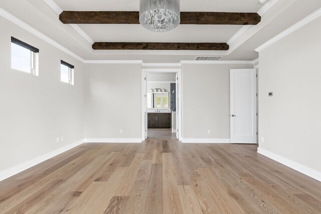 unfurnished room with visible vents, plenty of natural light, and beam ceiling