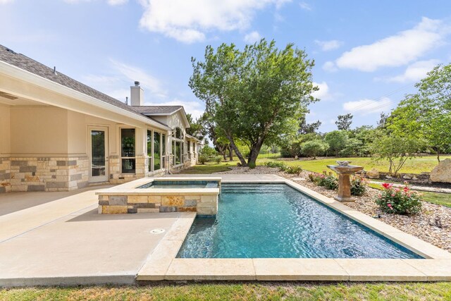view of pool with a patio and a pool with connected hot tub