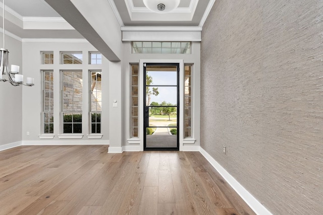2120 High Lonesome Dr, Leander, TX 78641 - entryway featuring wood-type flooring, ornamental molding, a chandelier, a high ceiling, and a tray ceiling