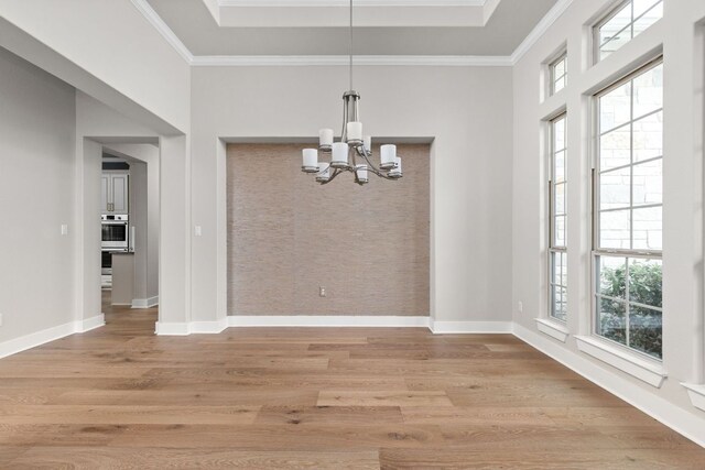 unfurnished dining area with light wood-style floors, baseboards, and a notable chandelier